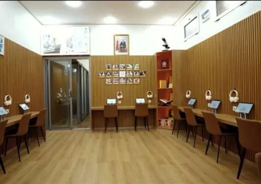 Wider view of the room with desks, tablets and a glass door at the back.
