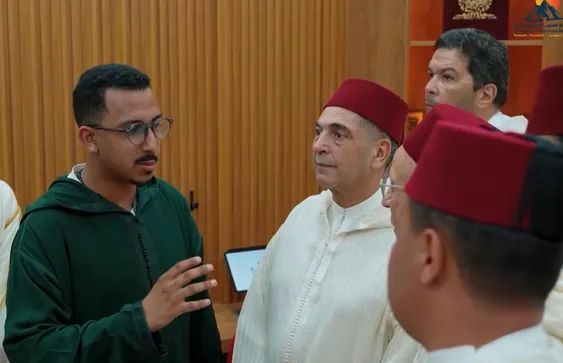 Youssef Nidam presenting a tablet to the Minister of Religious Affairs and officials in the AI Quranic education room.