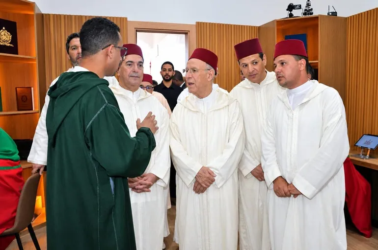 Youssef Nidam speaking with the Minister and officials in white djellabas during the visit.