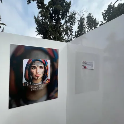 Outdoor panel showing an AI portrait of a woman in a headscarf.