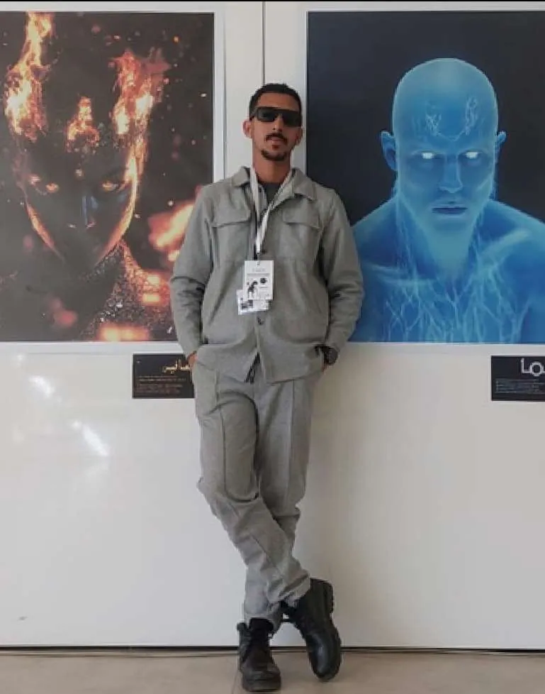 Youssef Nidam standing between two large AI portraits, one made of fire and one of blue water.